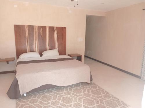 a bedroom with a large bed and a rug at AHAL in Chemuyil