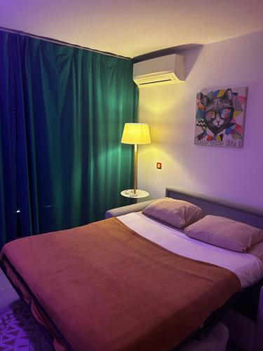 - une chambre avec un lit et un rideau vert dans l'établissement Studio/f1bis à 50 m de la plage, à Argelès-sur-Mer