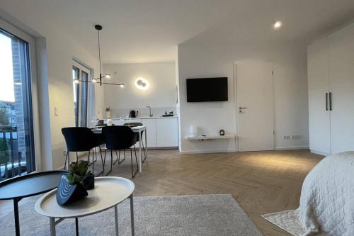 1 dormitorio con 1 cama, mesa y sillas en Stilvolles Ferinen-Apartment im Herzen von Xanten, en Xanten