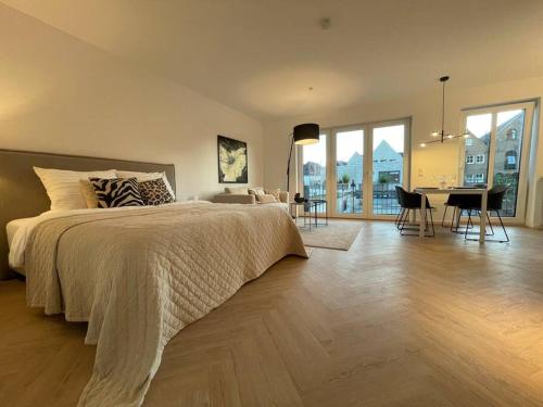 1 dormitorio con 1 cama grande y comedor en Stilvolles Ferinen-Apartment im Herzen von Xanten, en Xanten