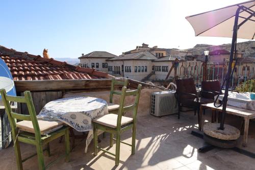 a patio with a table and chairs and an umbrella at Born Hotel in Urgup