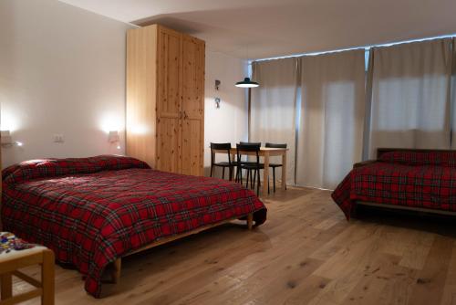 sypialnia z dwoma łóżkami i stołem oraz jadalnia w obiekcie White Escape w mieście Valtournenche