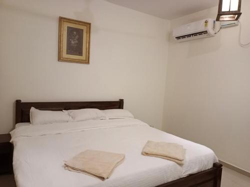 a bedroom with a bed with two towels on it at Ronne's aparthotel in Arpora