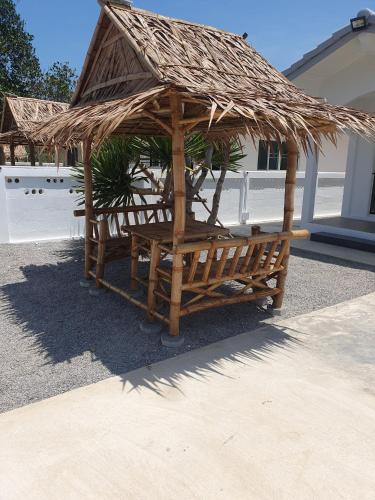 a wooden shelter with a straw roof at S&F villa in Sam Roi Yot