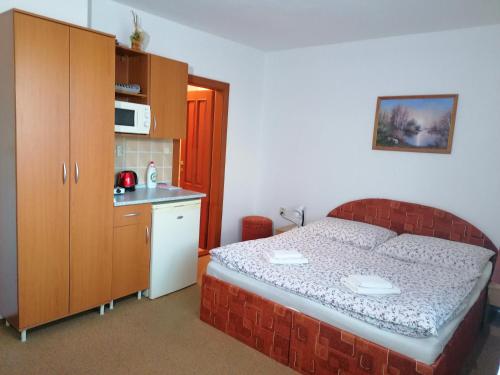 a small bedroom with a bed and a kitchen at Apartmány AQUAVILLA in Liptovský Trnovec