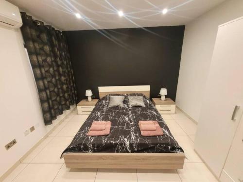a bedroom with a bed with two pillows on it at New&Cosy Apartment with Balcony in San Ġwann