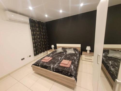 a bedroom with two beds and a black wall at New&Cosy Apartment with Balcony in San Ġwann