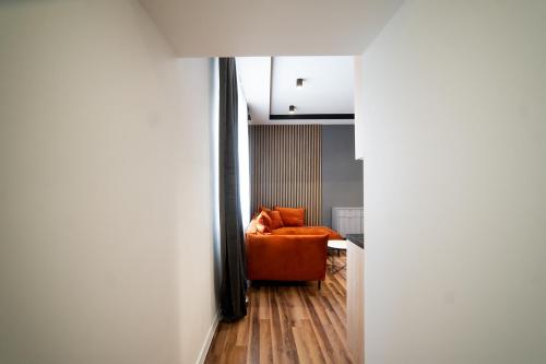 a living room with an orange chair in a room at Apartament Premium 25 Czerwca in Radom