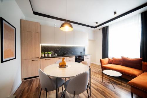 a living room with a table and chairs and a couch at Apartament Premium 25 Czerwca in Radom