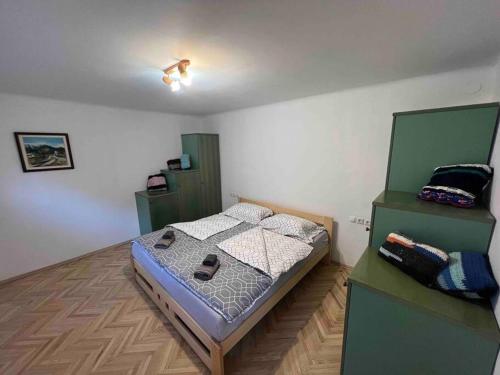 a bedroom with a bed and two green cabinets at Tiny Bled house in Bled