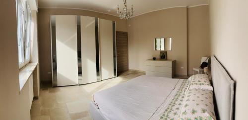 a bedroom with a white bed and a mirror at Villa Raffaele in Trani