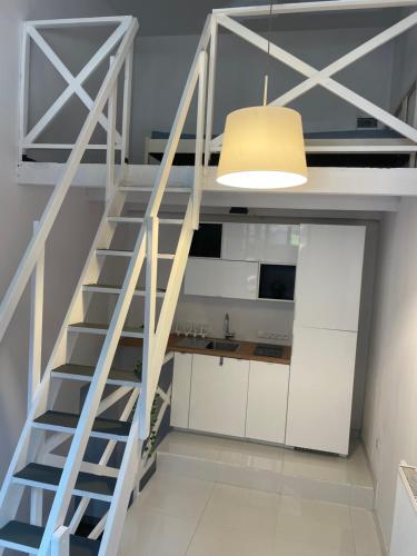 a staircase in a kitchen with a light fixture at Apartament Wspólna in Sosnowiec