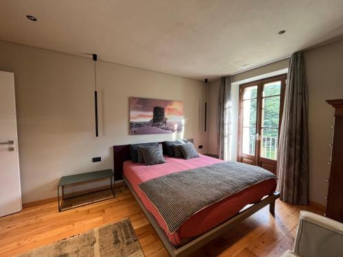 a bedroom with a bed and a large window at Casa di Sant'Anselmo - Il Parco - CIR VDA AOSTA 0191 in Aosta