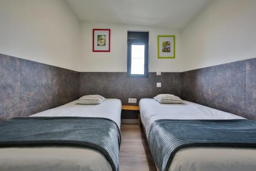 2 Einzelbetten in einem kleinen Zimmer mit Fenster in der Unterkunft CHALET CAMPAGNE Les Belles Ouvrières in Clermont-Créans