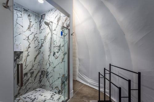 a bathroom with a walk in shower next to a staircase at Sequoia Studio Suites in Three Rivers