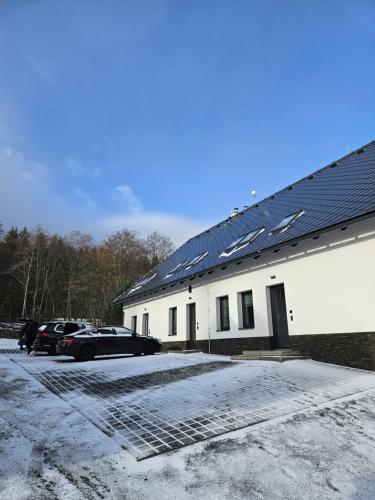 Horský apartmán MIKI في Filipovice: مبنى به لوحات شمسية على جانبه
