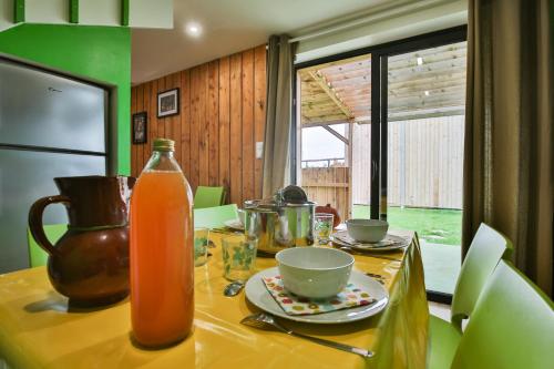 una mesa de cocina con una botella de zumo de naranja. en CHALET CAMPAGNE Les Belles Ouvrières, en Clermont-Créans