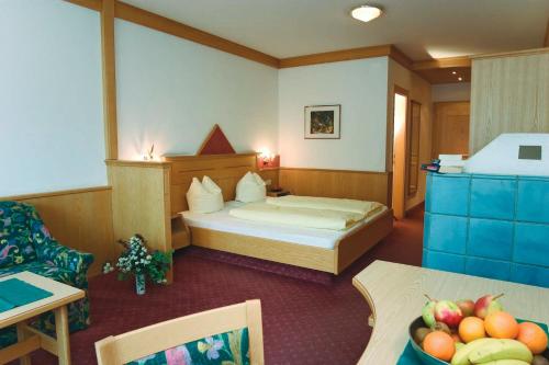 a hotel room with a bed and a table with a bowl of fruit at Gasthof Pitztaler Hof in Wenns