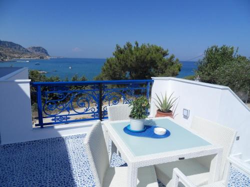 a white table and chairs on a balcony with the ocean at Bouganville Studios Stegna in Archangelos