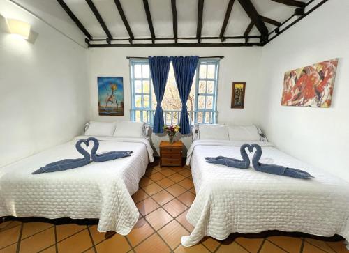 Dos camas en una habitación con cisnes. en Casa chalet Campestre 2km, en Villa de Leyva