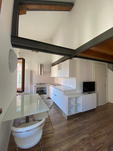 a kitchen with white cabinets and a white table at Savorgnan 1593 in Palmanova