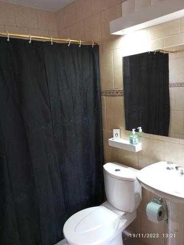 La salle de bains est pourvue de toilettes et d'un rideau de douche noir. dans l'établissement Elal kayak, à Comandante Luis Piedrabuena