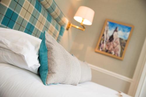 a bedroom with a bed with a pillow and a lamp at Hazel Bank Country House Borrowdale Valley in Rosthwaite