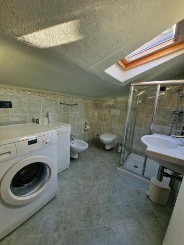 uma casa de banho com uma máquina de lavar roupa e um lavatório em Casa Vittoria Sirmione Punta Grò con Piscina em Sirmione