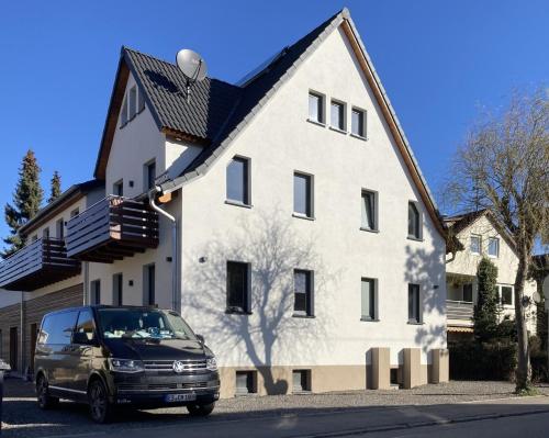a van parked in front of a white house at Filder-Appartements in Filderstadt
