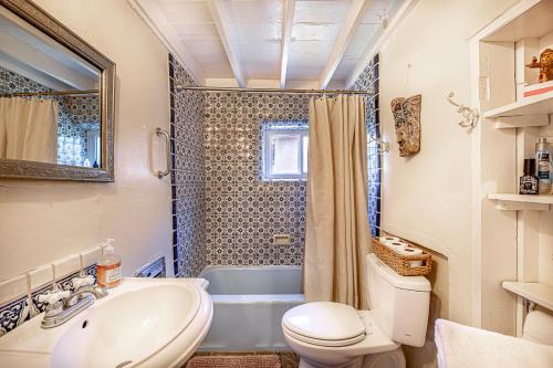 a bathroom with a toilet and a sink and a tub at Pet Friendly Piñon Heaven in Santa Fe