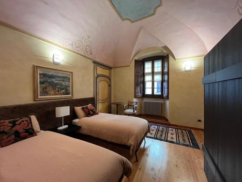 アオスタにあるCasa di Sant'Anselmo - Le Volte - CIR VDA AOSTA 0190のベッド2台と窓が備わるホテルルームです。