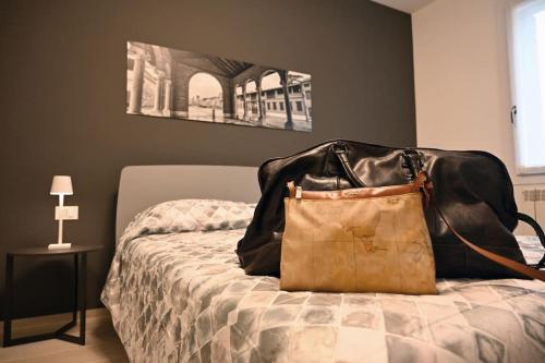 een handtas op een bed bij Ca' Milla Apartment Noale Centro Storico in Noale