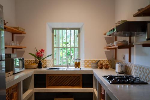 a kitchen with a sink and a stove at Sukomala Imaduwa in Ahangama