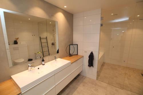 a bathroom with a sink and a large mirror at Pepsitoppen Villa in Tau