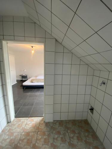 a bathroom with a room with a bed in the background at Schnuggeliches Apartment in Gerbrunn