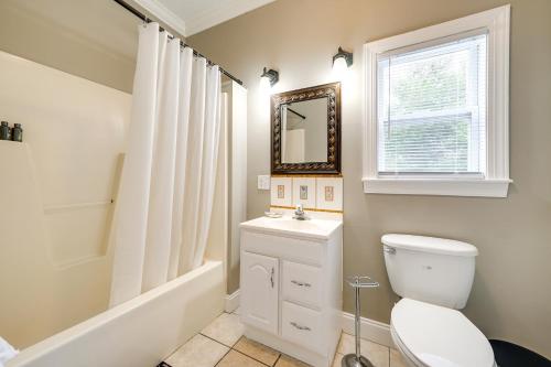 Un baño con inodoro, lavabo y espejo. en Downtown Wilmington Home Walk to Cape Fear River!, en Wilmington