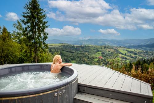 a man in a jacuzzi tub in the mountains at Rest Hub in Slavske