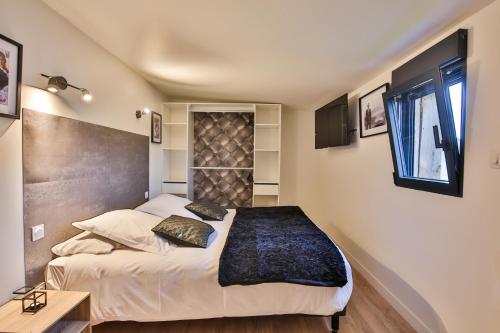 Un dormitorio con una cama grande y una ventana en CHALET CINEMA - Les Belles Ouvrières, en Clermont-Créans
