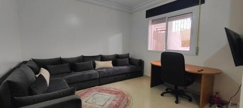 sala de estar con sofá negro y mesa en Elegant 2BR Tangier Apartment, en Tánger