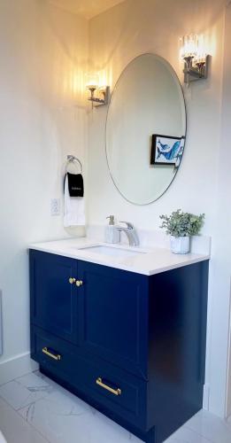 a bathroom with a blue sink and a mirror at Bambury's Hillside Chalets in Rocky Harbour