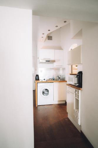 une cuisine blanche avec une machine à laver à l'intérieur dans l'établissement CANNES CENTRE VILLE- Bel appartement studio + Mezzanine, à Cannes