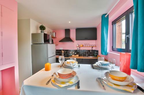 a kitchen with a table with plates and dishes on it at CHALET CARAIBES SPA Privatif in Clermont-Créans