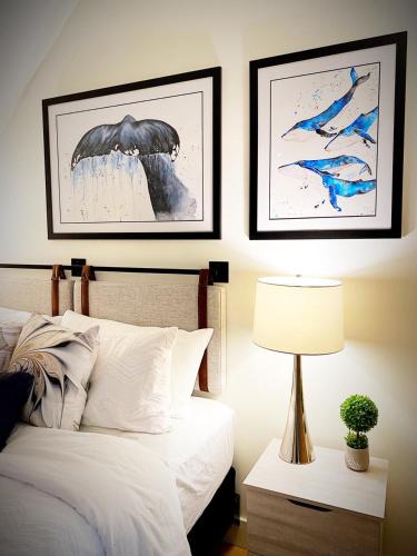 a bedroom with a bed and two pictures on the wall at Bambury's Hillside Chalets in Rocky Harbour