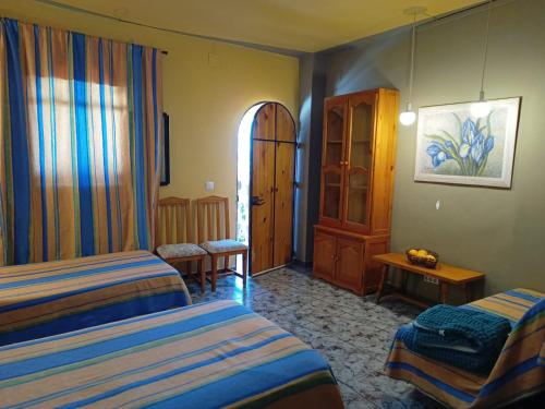 een hotelkamer met 2 bedden en een raam bij Casa Proyecto Pepe Bravo - Arte de manos y corazón in Alozaina