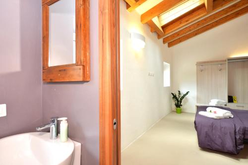 a bathroom with a sink and a mirror and a bed at Agriturismo Tre Forti in Rivoli Veronese