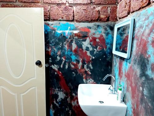 a bathroom with a sink and a painting on the wall at The Dream in SanivÄrsante