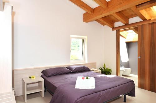 a bedroom with a purple bed and a window at Agriturismo Tre Forti in Rivoli Veronese