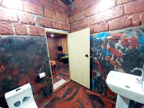 a bathroom with a white sink and a brick wall at The Dream in SanivÄrsante