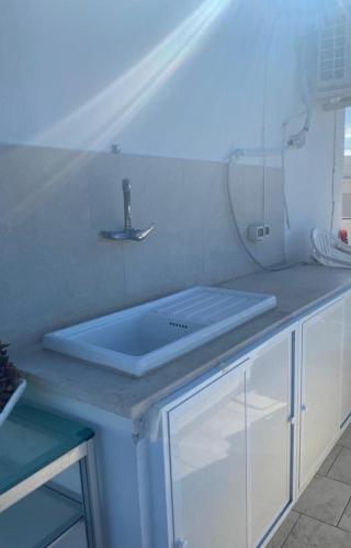 a kitchen counter with a sink and a mirror at A un passo dal mare in Villanova di Ostuni