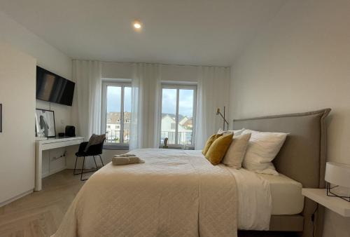 1 dormitorio con 1 cama blanca grande y ventana en Stilvolles Zimmer mit Bad im historischen Stadtkern von Xanten en Xanten